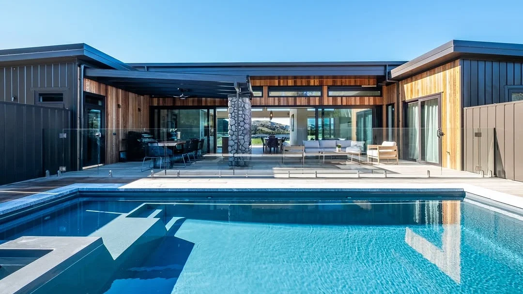 The Absolute 12.00m fibreglass swimming pool with a built-in spa is in the middle of the backyard, with white tiles and greenery surrounding it. The pool colour is shimmer white makes the fibreglass swimming pool glow in the sunlight. The Absolute 8.00m fibreglass swimming pool with a built-in spa is built at the heart of a contemporary design complex with white tiles surrounding it. The pool and built-in spa come in Graphite Grey colour, while the house is in yellow and brown.
